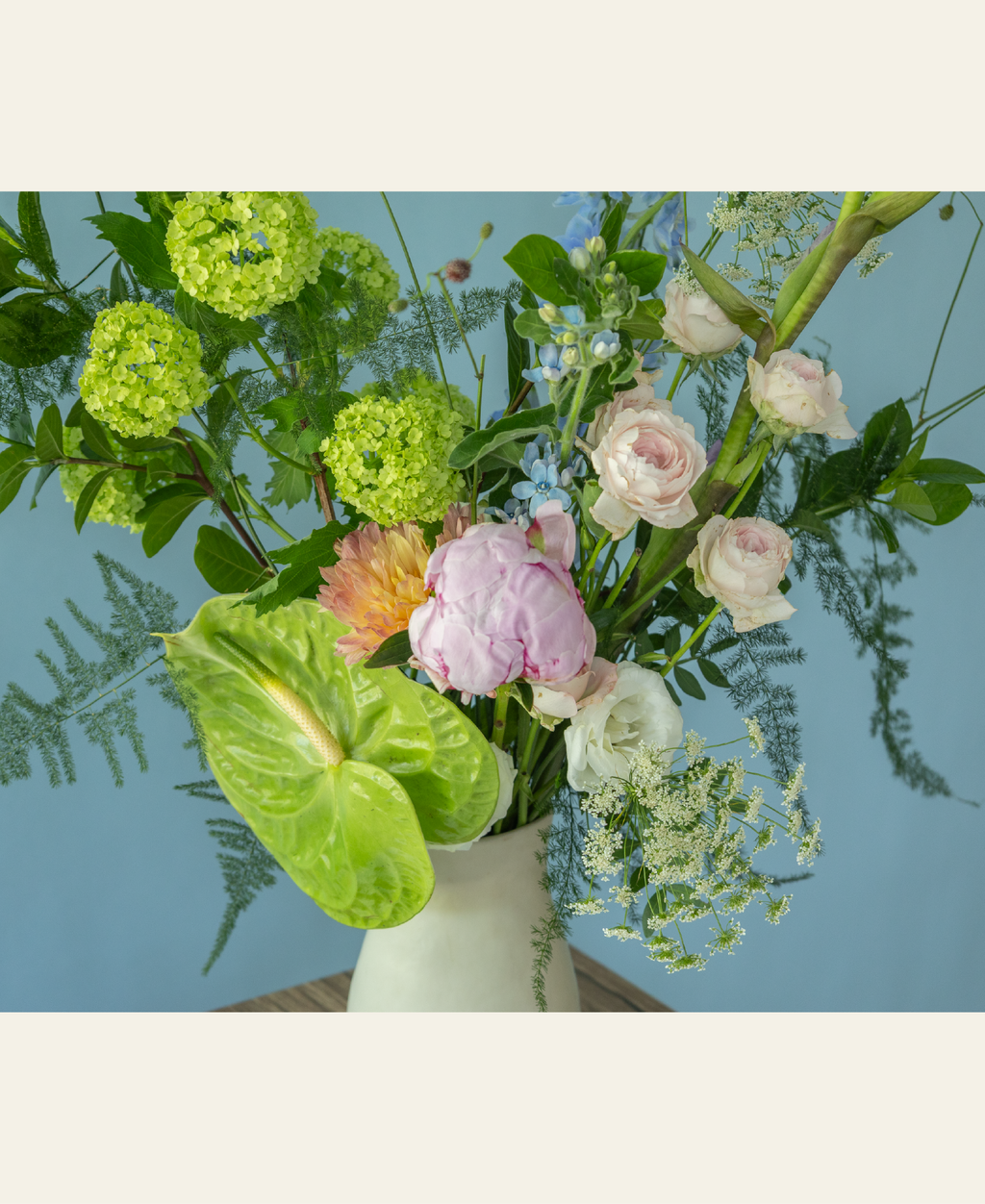 Elegant peony flower arrangement in a hand-crafted ceramic vase by Charlotte Puxley Flowers Singapore, showcasing seasonal pink peonies, spray roses, and lush summer greenery.