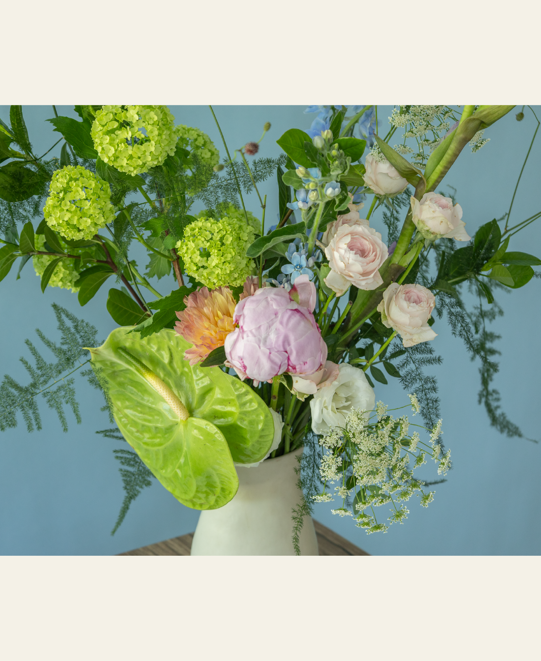 Elegant peony flower arrangement in a hand-crafted ceramic vase by Charlotte Puxley Flowers Singapore, showcasing seasonal pink peonies, spray roses, and lush summer greenery.