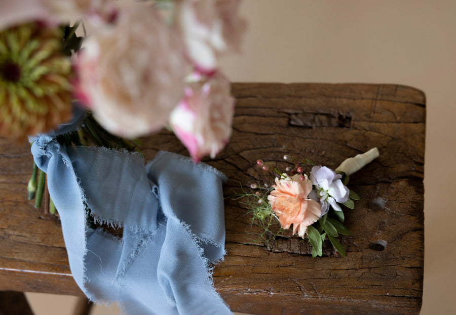 Boutonnière in Great Dixter Pastels on wooden table
